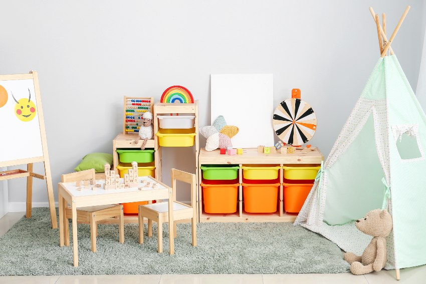 Interior of exciting playroom with play tent, wooden furniture, baskets and other unique storage options for storing toys