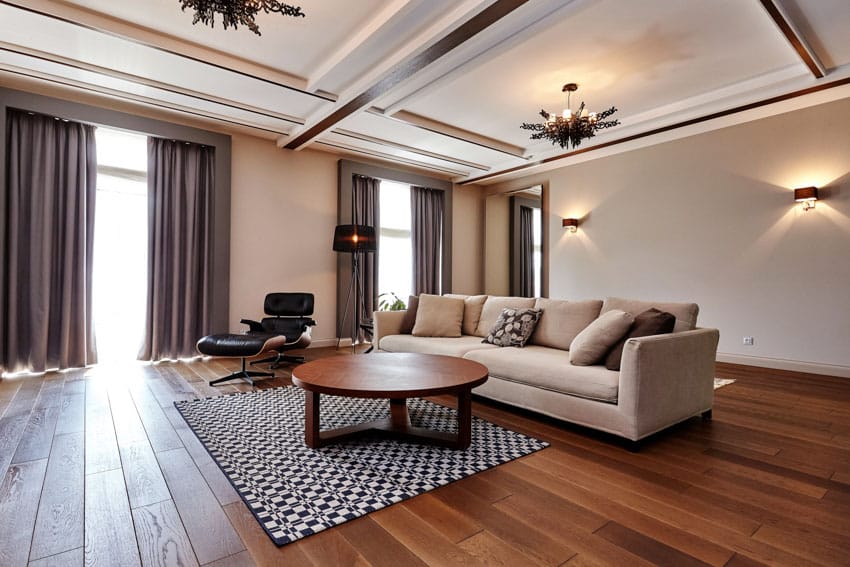Spacious room with beige sofa, geometric design rug and wooden center table