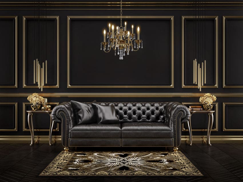 Living room with Hollywood regency style furniture, leather sofa, side table, rug, black and gold walls