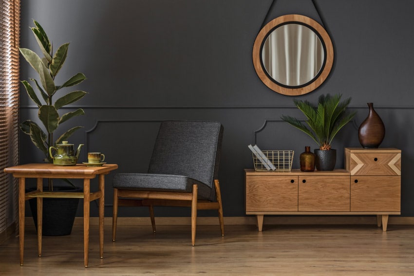 Room with small deodar cabinet, cushioned chair and indoor plants