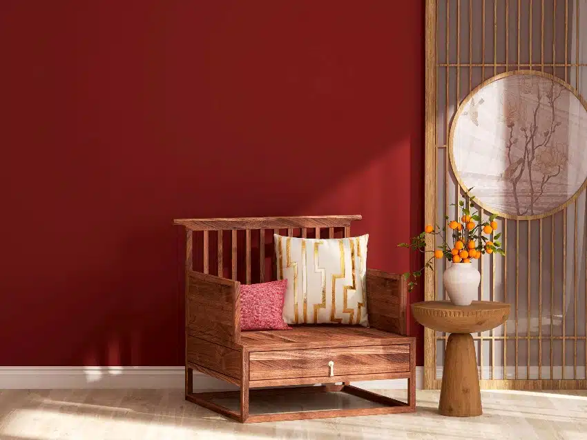 Maroon wall living room with antique wooden chair and side table with lucky orange plants in a pot decoration in a zen style living room