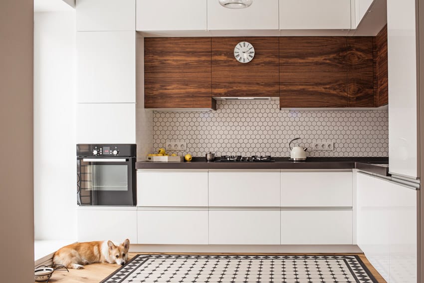 Minimalist kitchen with birds eye grain cabinets, hexagon backsplash, stove, and oven