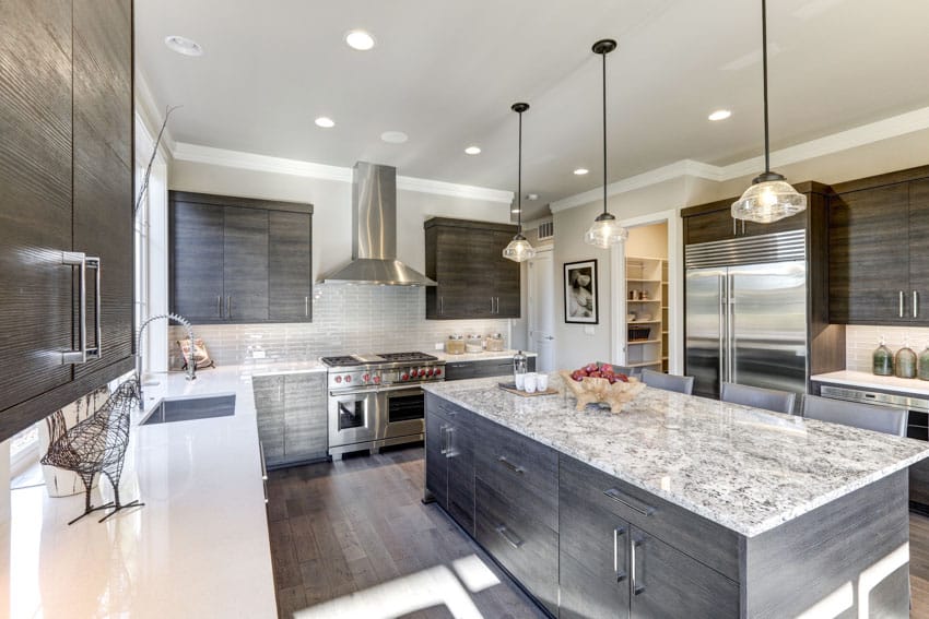 Modern kitchen with gray wood grain cabinets, granite countertop, island, backsplash, pendant lights, and range hood