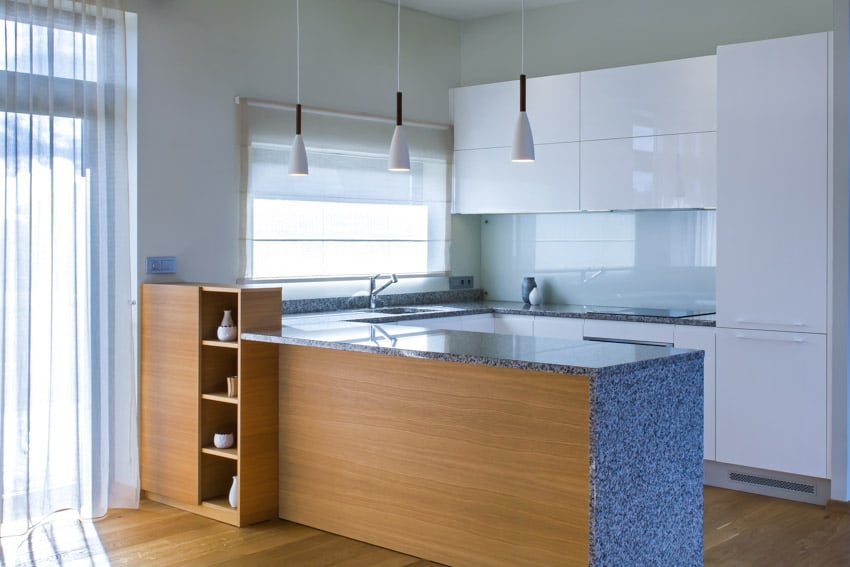 Modern kitchen with peninsula, granite countertops, and glass backsplash
