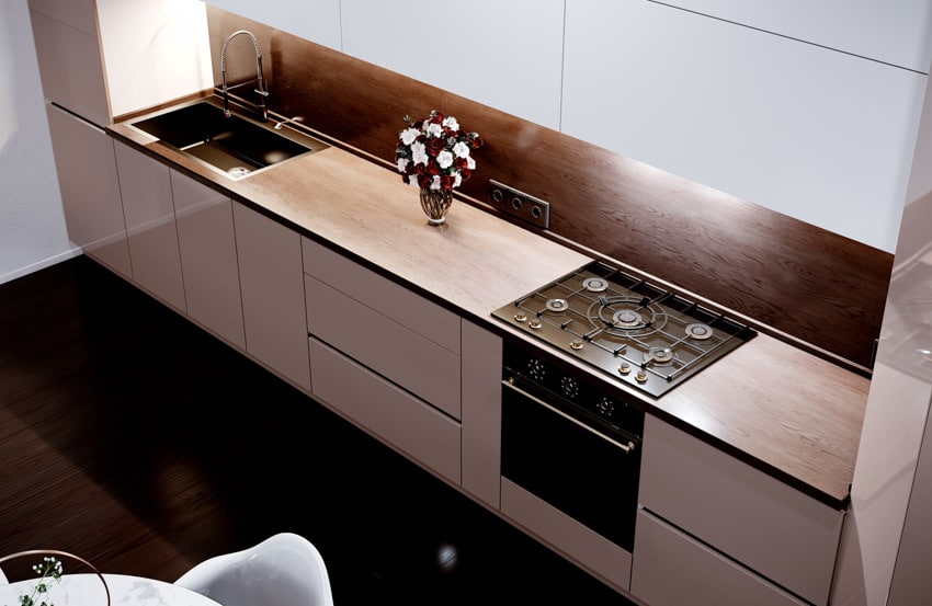 Modern kitchen with cabinets, backsplash, and teak wood countertop