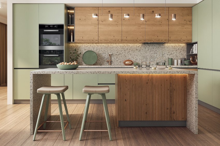 Modern spacious kitchen with a free standing kitchen island, light green and wooden cabinets combined with light gray terrazzo countertops