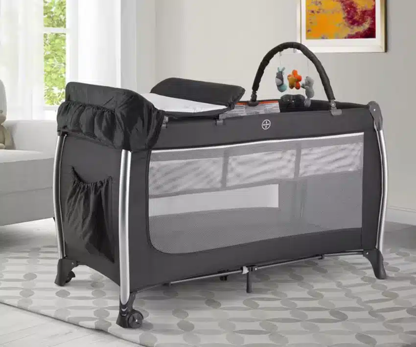 Nursery room with crib top changing pad, floor rug, and window
