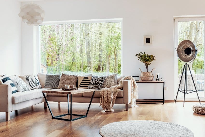 Farmhouse industrial style living room interior with beige sofa and dark hardwood floors