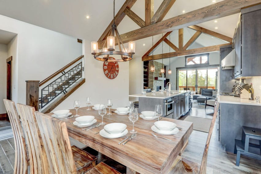 Sandalwood table, chairs, wagon wheel chandelier and exposed ceiling beams