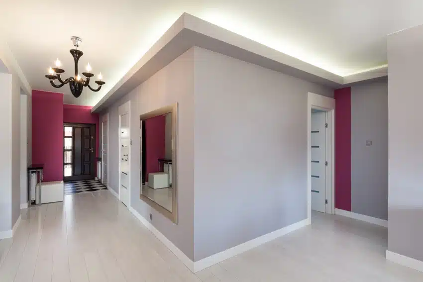 Small hallway with chandelier, light gray walls, and cove accent lights