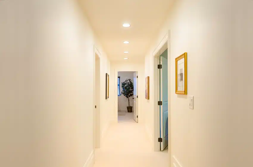 Small hallway with recessed lights, white walls, and doors