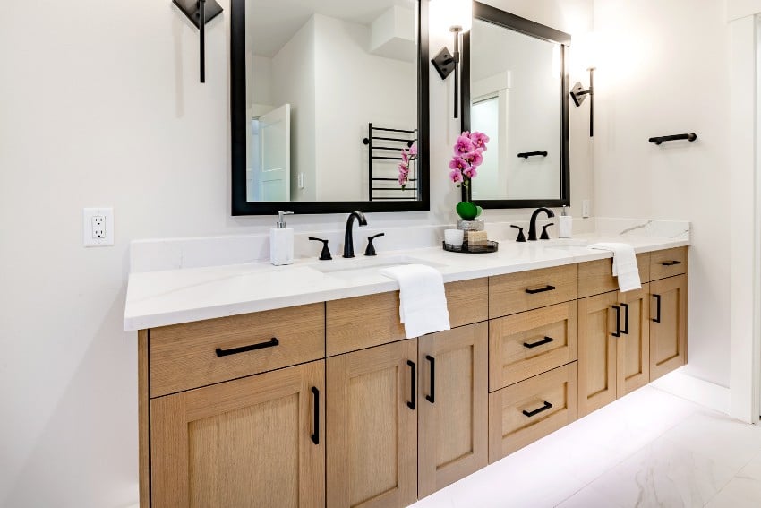 Spacious interior bathroom with vanity mirrors, faucet, hardwood cabinets and walk in closet