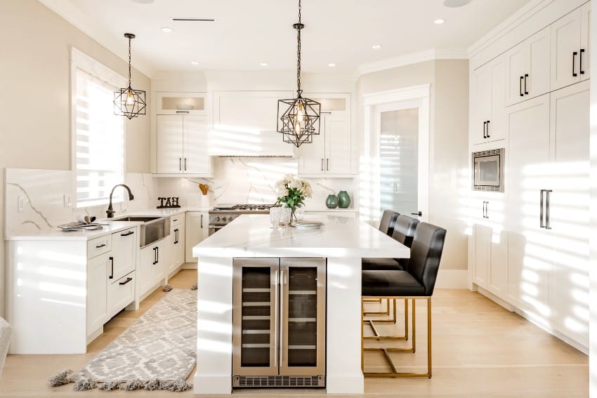 Warm white kitchen with countertops, RTF cabinet door sizes, island, high end appliances, leather chairs, and wine fridge