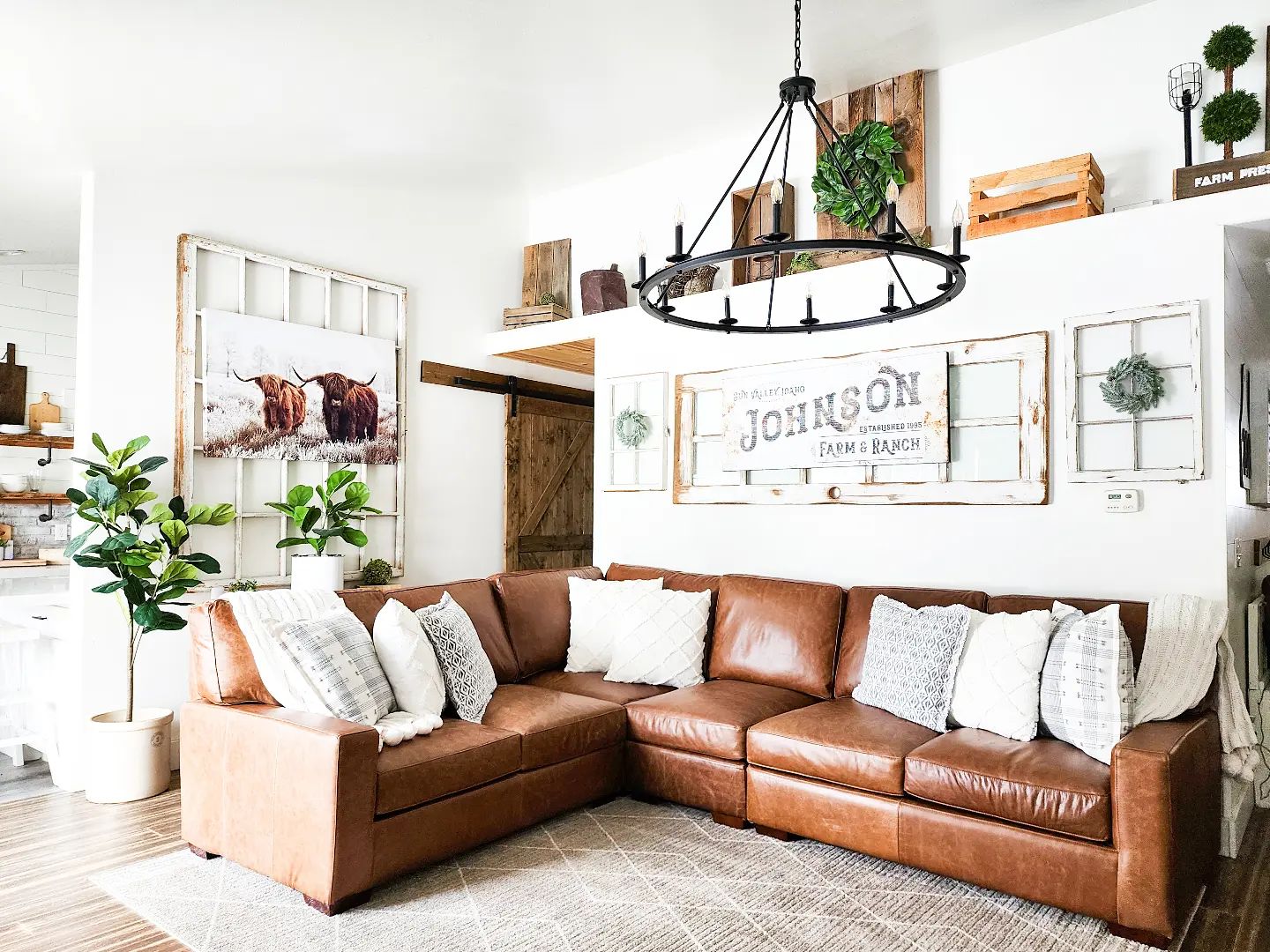 Living room with L- shaped sectional leather sofa, decor pieces, and chandelier