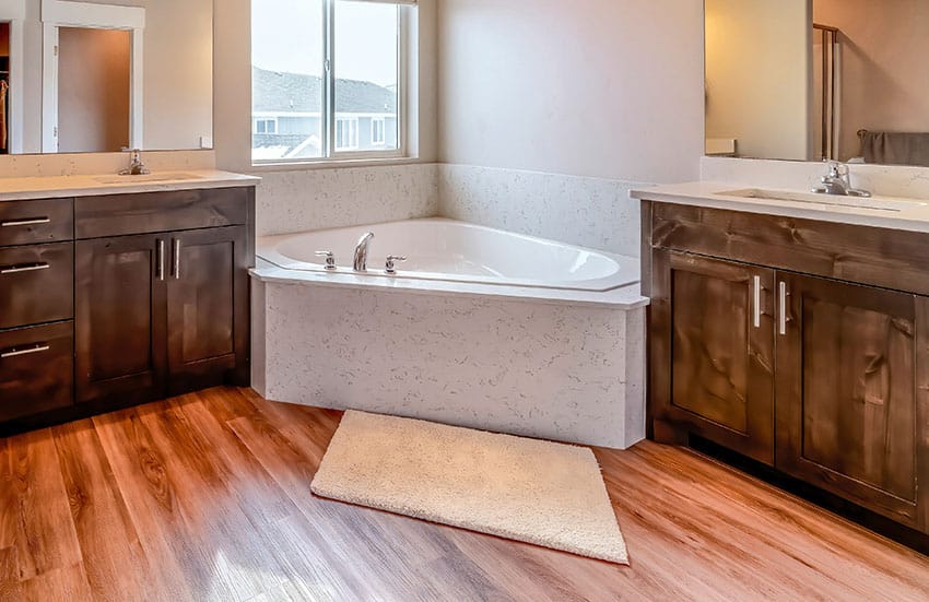 Bathroom with corner tub wooden floor sliding window bathroom rug