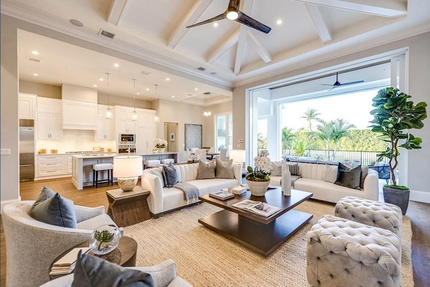 Beach house great room with spacious living room, coffee table, ottomans, and ceiling fan
