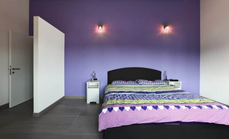Bedroom With Purple Paint Walls Headboard Comforter Nighstand And Wall Sconces Ss 758x461 
