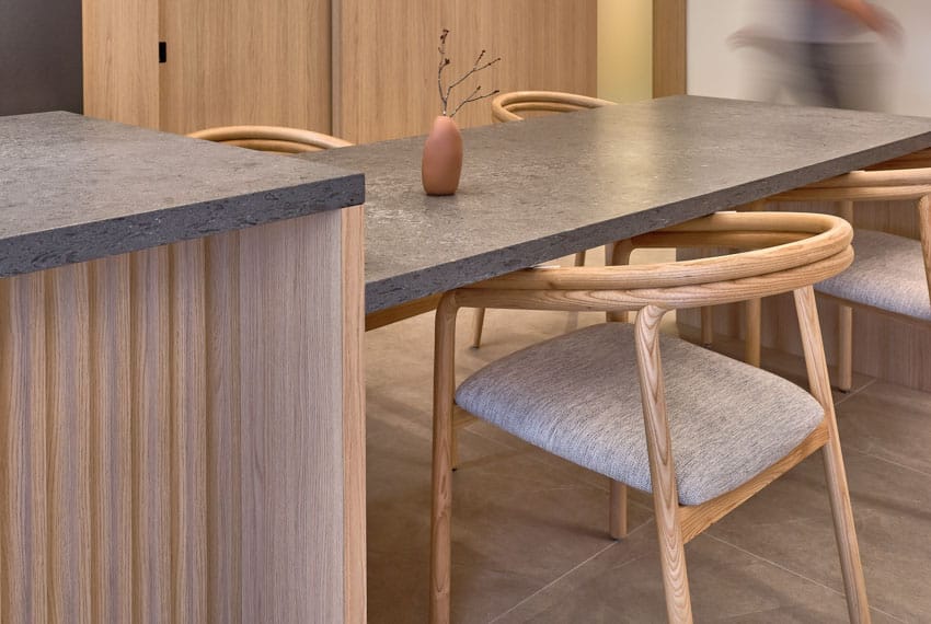 Harty house interior kitchen with concrete countertop, dining space, chairs, and wood flooring