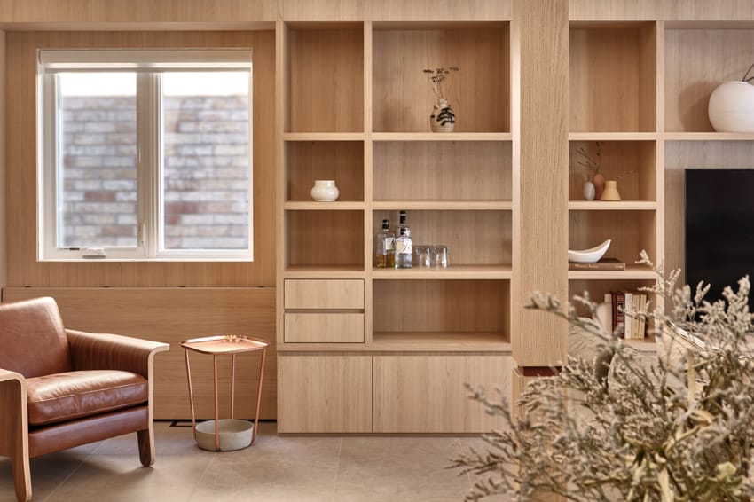 Harty house interior living room with armchair, wood shelves, and side table