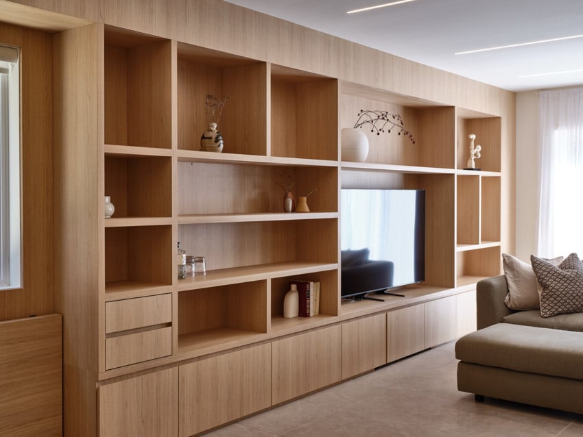 Harty house interior living room with television, wooden shelves, cabinets, and nooks