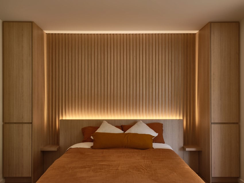 Harty house bedroom with small floating nightstand, accent lighting, and wood slat accent wall