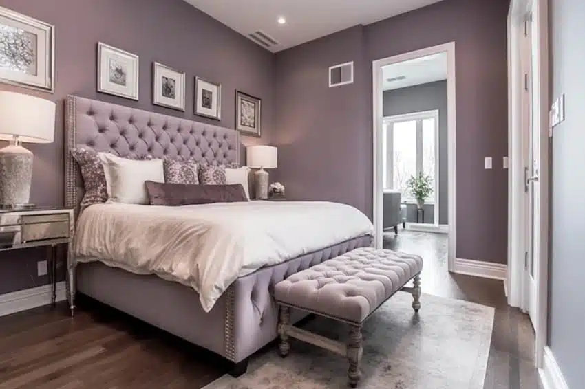 Modern bedroom with Sherwin Williams ash violet paint walls, ottoman, nightstands, and lamps 