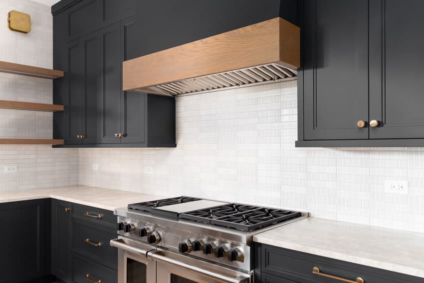 modern farmhouse kitchen with tile backsplash black countertops stove range hood and floating shelves