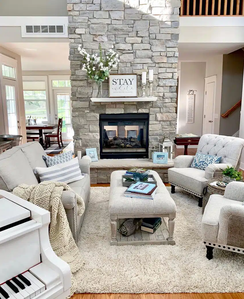 Sitting area with comfy couches, ottoman, stone fireplace and mantle