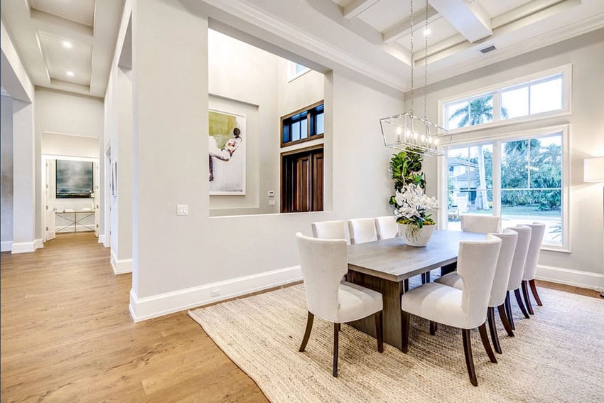 Beach house dedicated dining room for guests with table, chairs, windows, and pendant lights