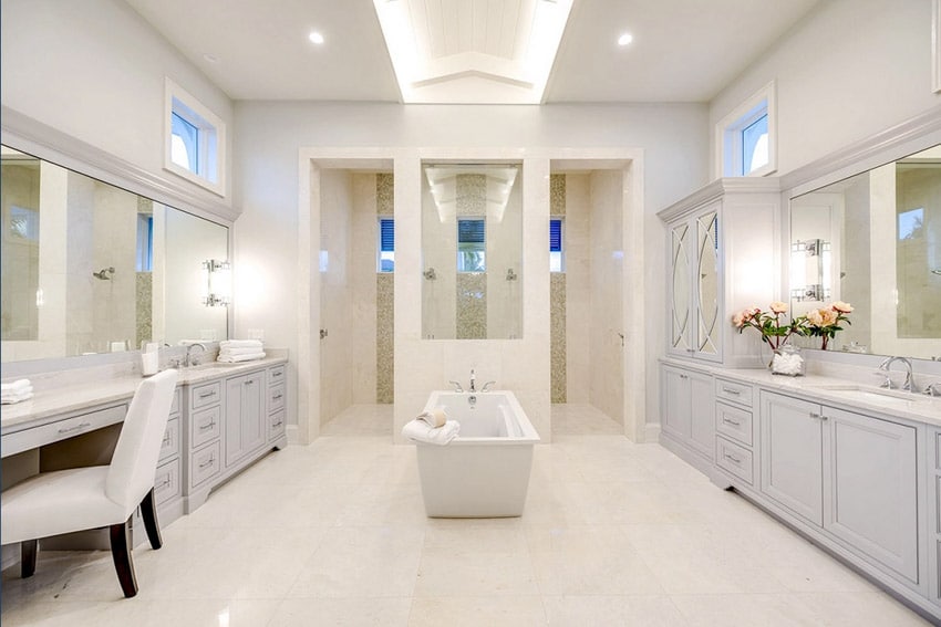 Beach house master bathroom with freestanding tub, vanity mirrors, and cabinets