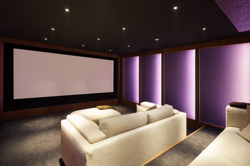 Spacious basement with purple accent lighting, and cushioned sofa