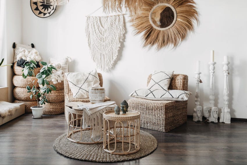 Living room with wood flooring, wicker materials, chairs, coffee tables, floor rug, and boho decor pieces