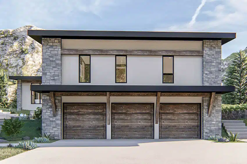Exterior with 3-car garage, stone wall cladding, windows, and driveway