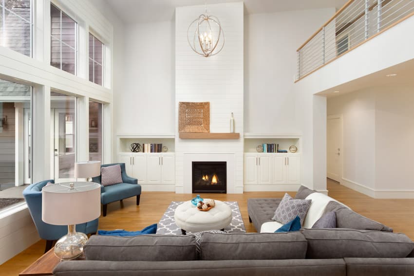 Room with white wall planking fireplace, mantel, and high loft ceiling