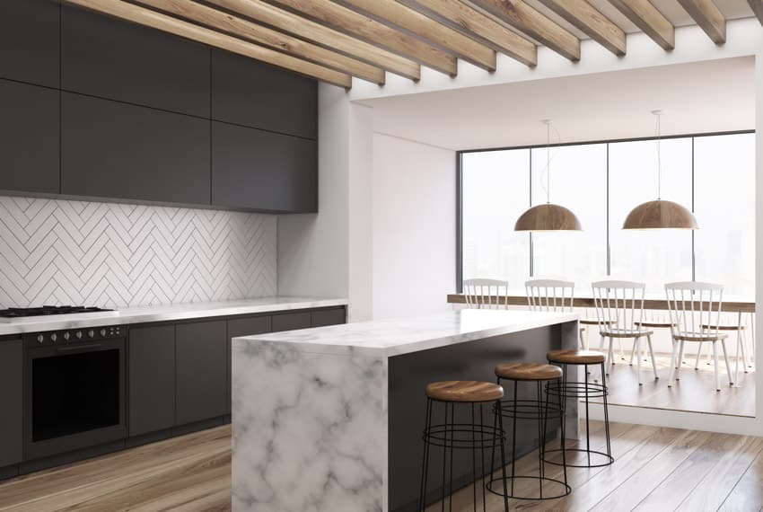 Kitchen with herringbone tile and waterfall island counter