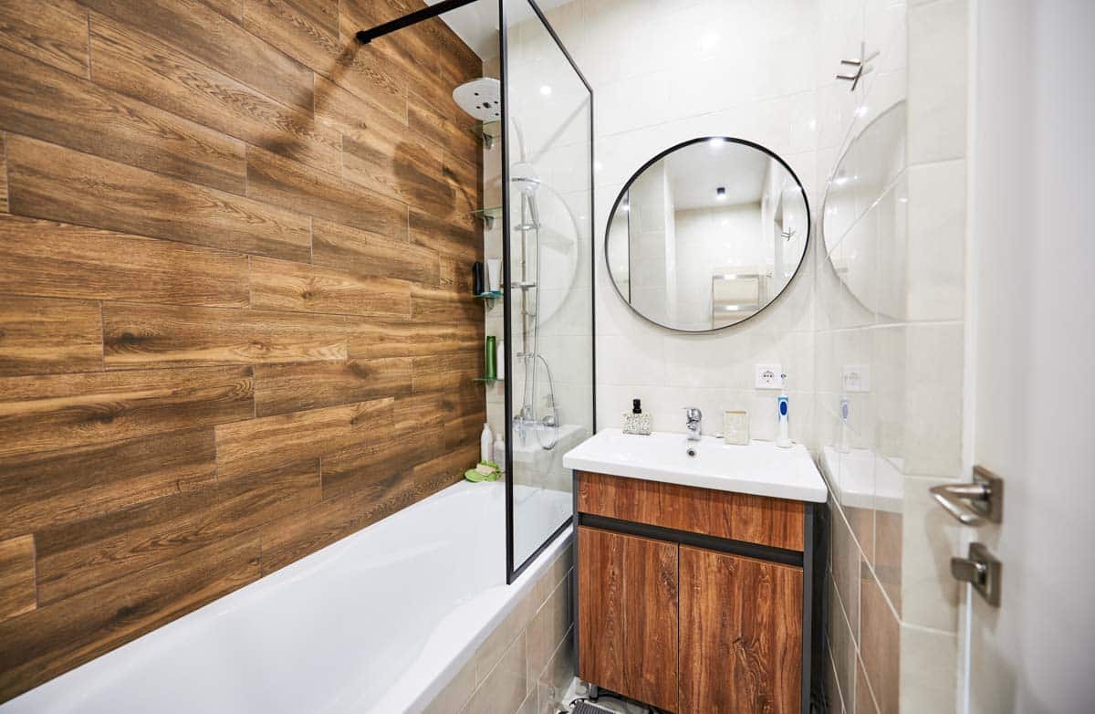 bathroom with wood shower wall and screen panel