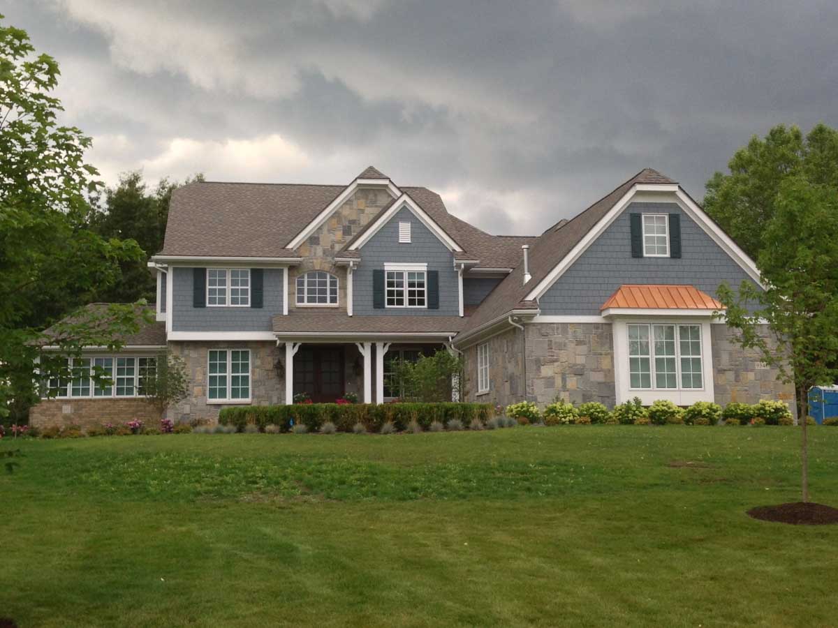 big house with blue gray walls and lawn