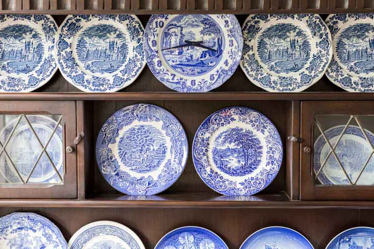 cabinet shelves with a collection of fine china plates on display