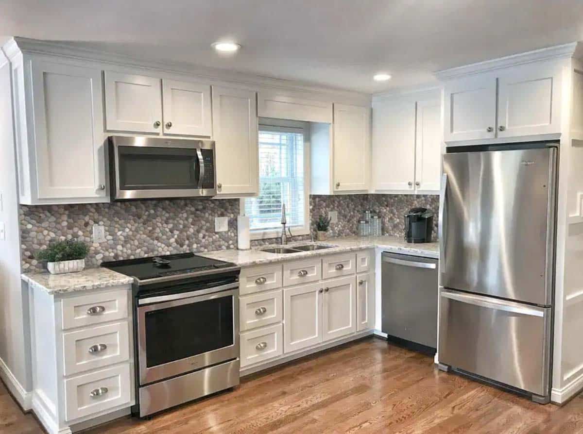 kitchen with white cabinets oven backsplash