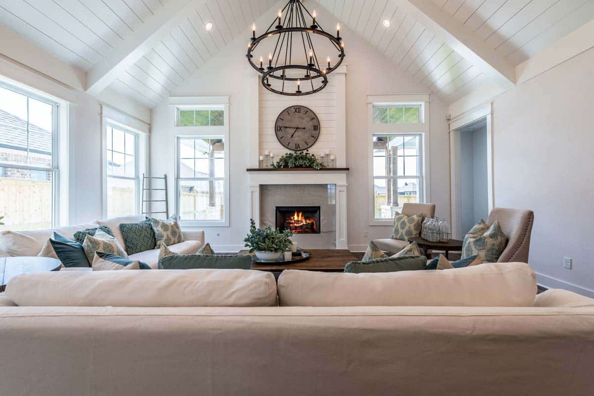living area with shiplap ceiling fireplace and chandelier