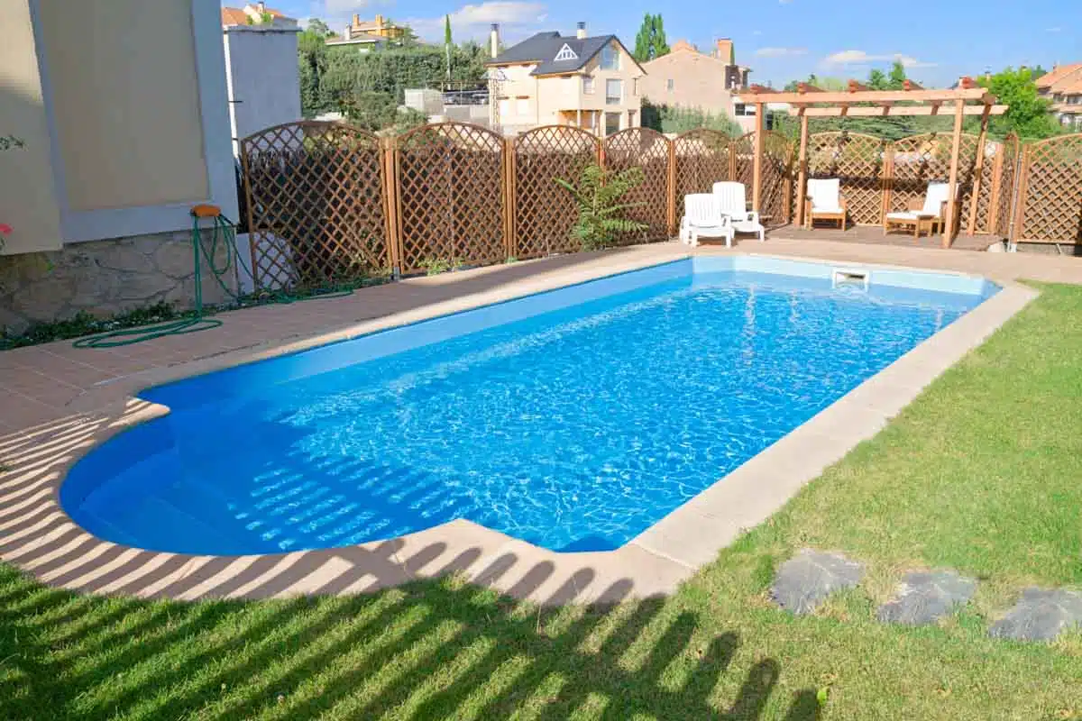 swimming pool area with trellis fence and pergola