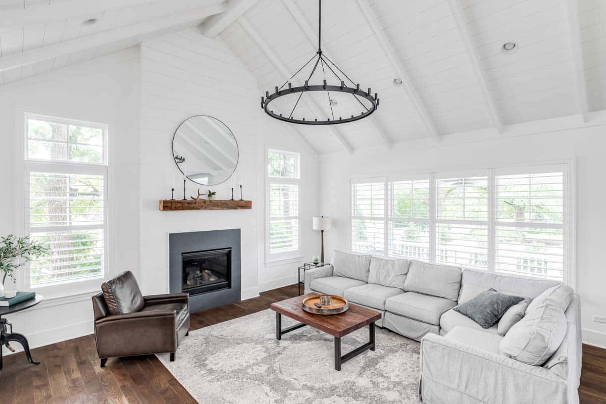 white room with vaulted ceiling sofa and chandelier