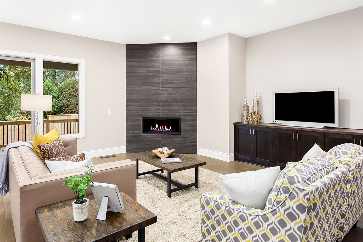 Corner fireplace with beige wall, rustic coffee table and loveseat