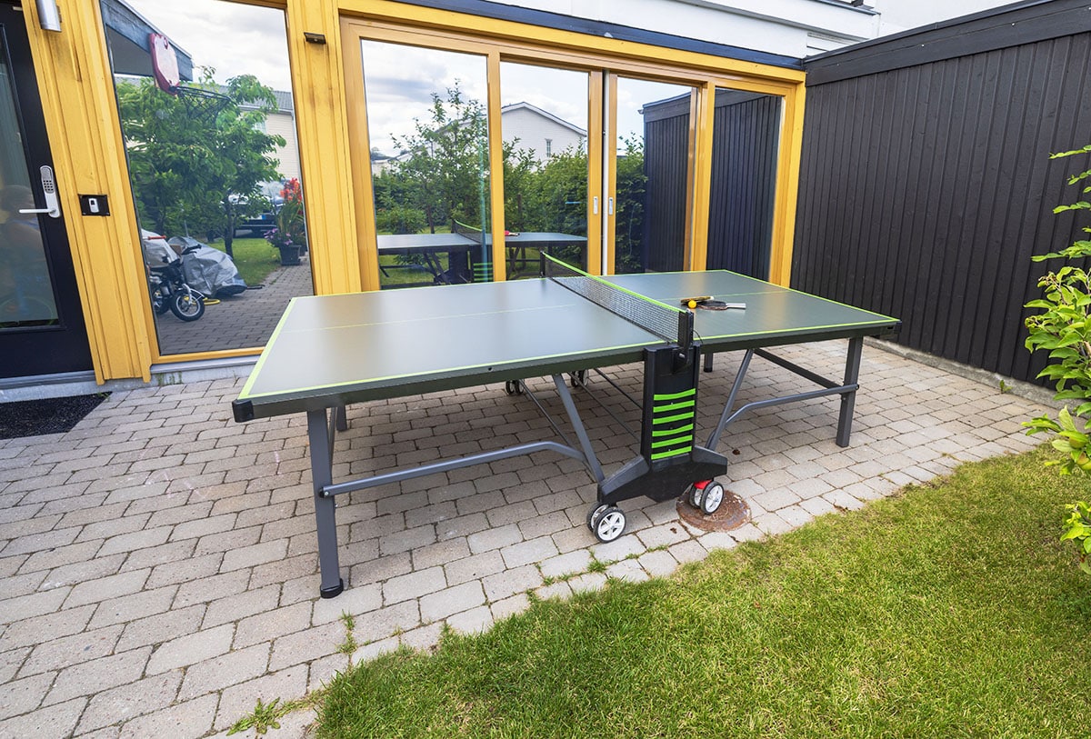 House patio with ping pong outdoor game and brick patio floor