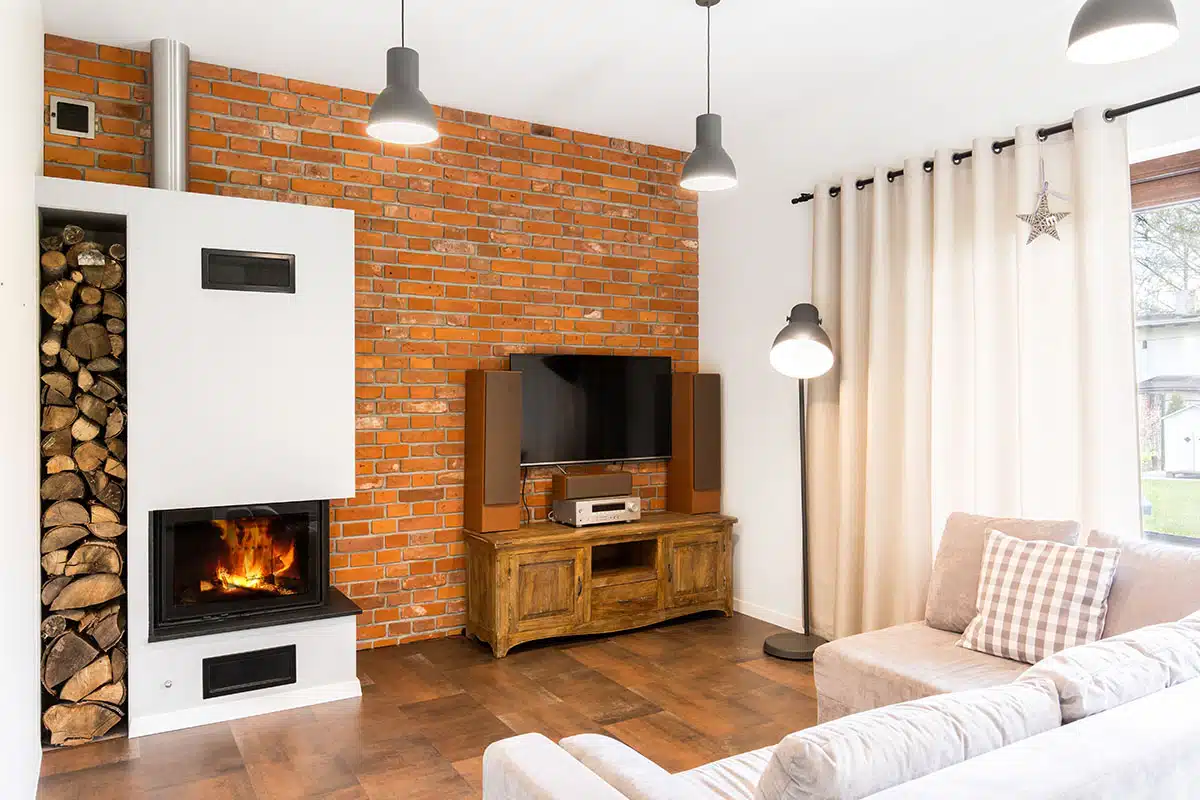 Small room with brick wall fireplace and pendant lights