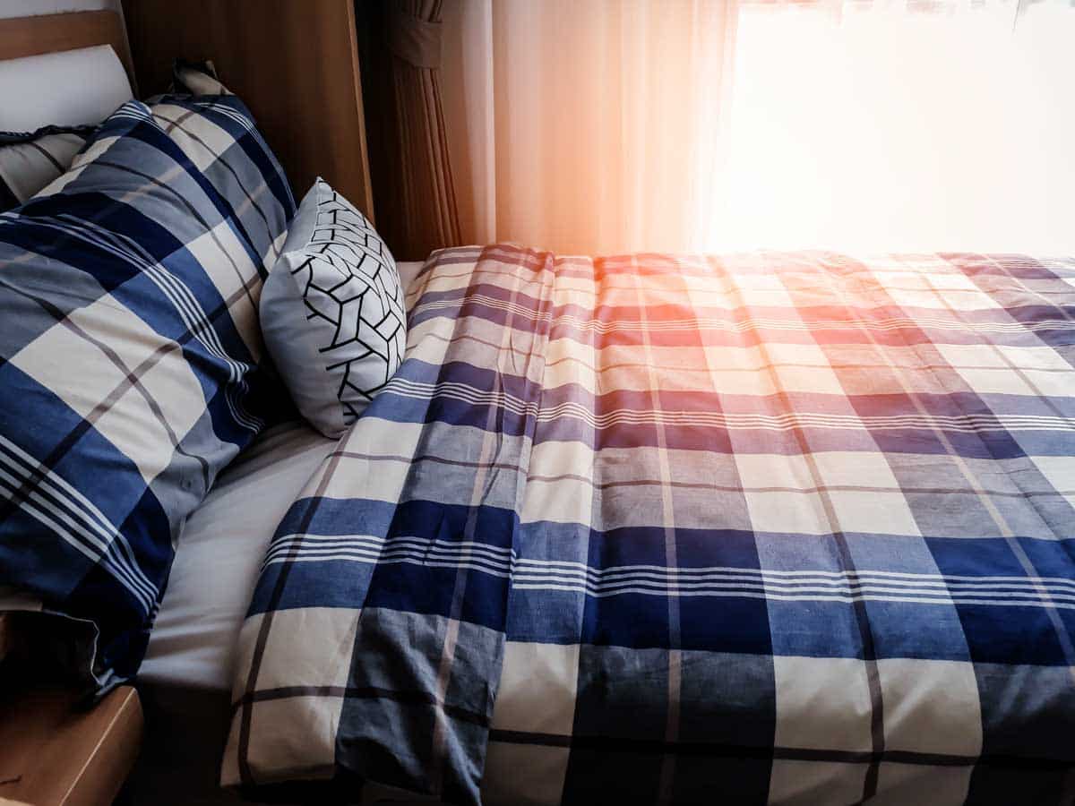 bed with pillows and blue sheet