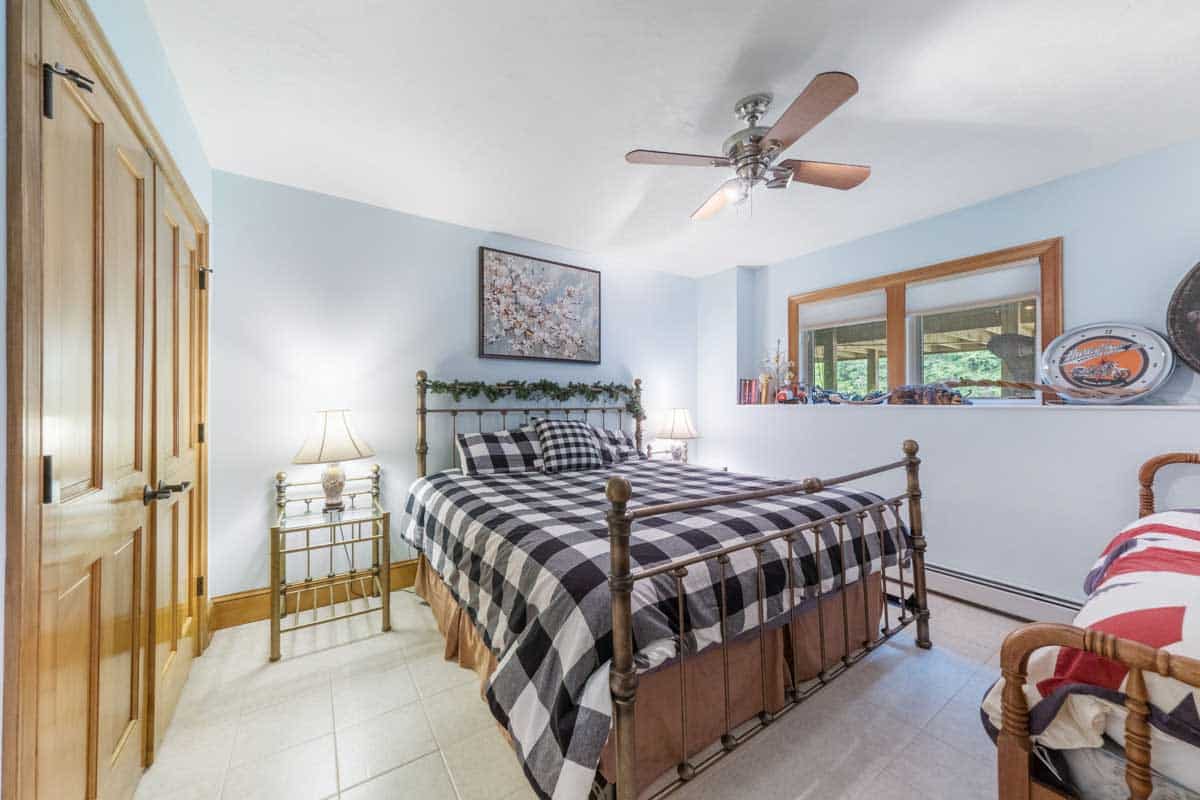 The room features wooden cabinets, flannel sheets and a ceiling fan.