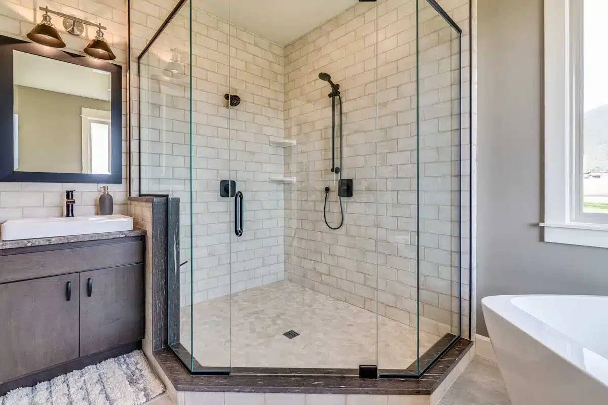 bathroom with brick wall and shower enclosure