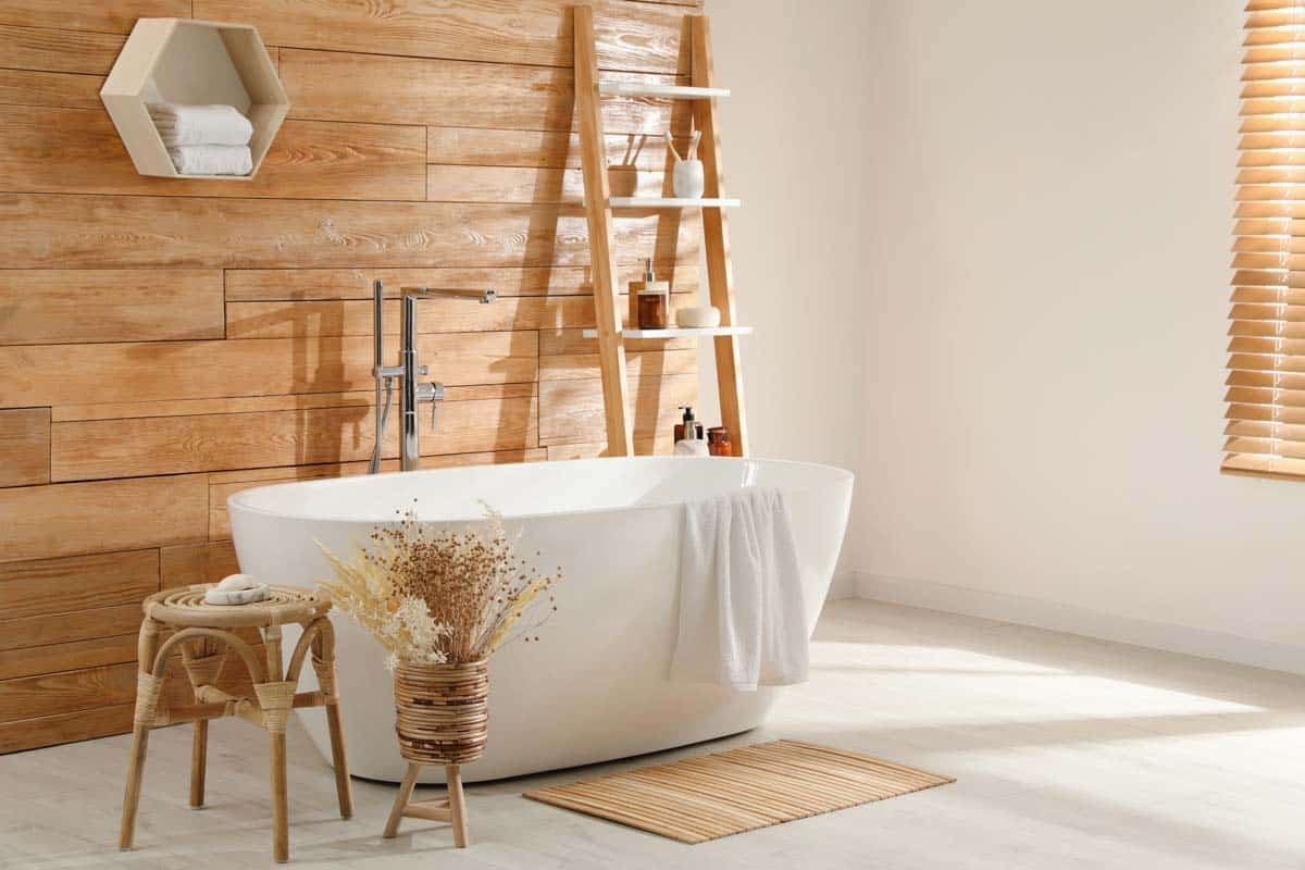 bathroom with wood plank wall tub and wool rug
