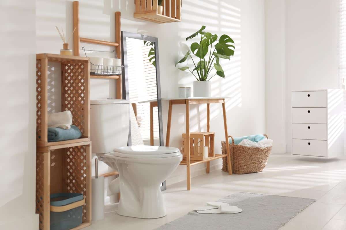 bathroom with wood shelves mirror and basket